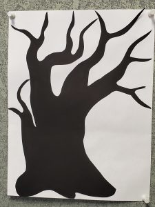 Black cut-paper silhouette of a bare tree