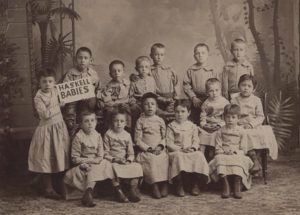 Group of Native American children at Haskell Institute, Lawrence, Kansas, between 1880 and 1889. One of the children, is holding a sign "Haskell Babies". 