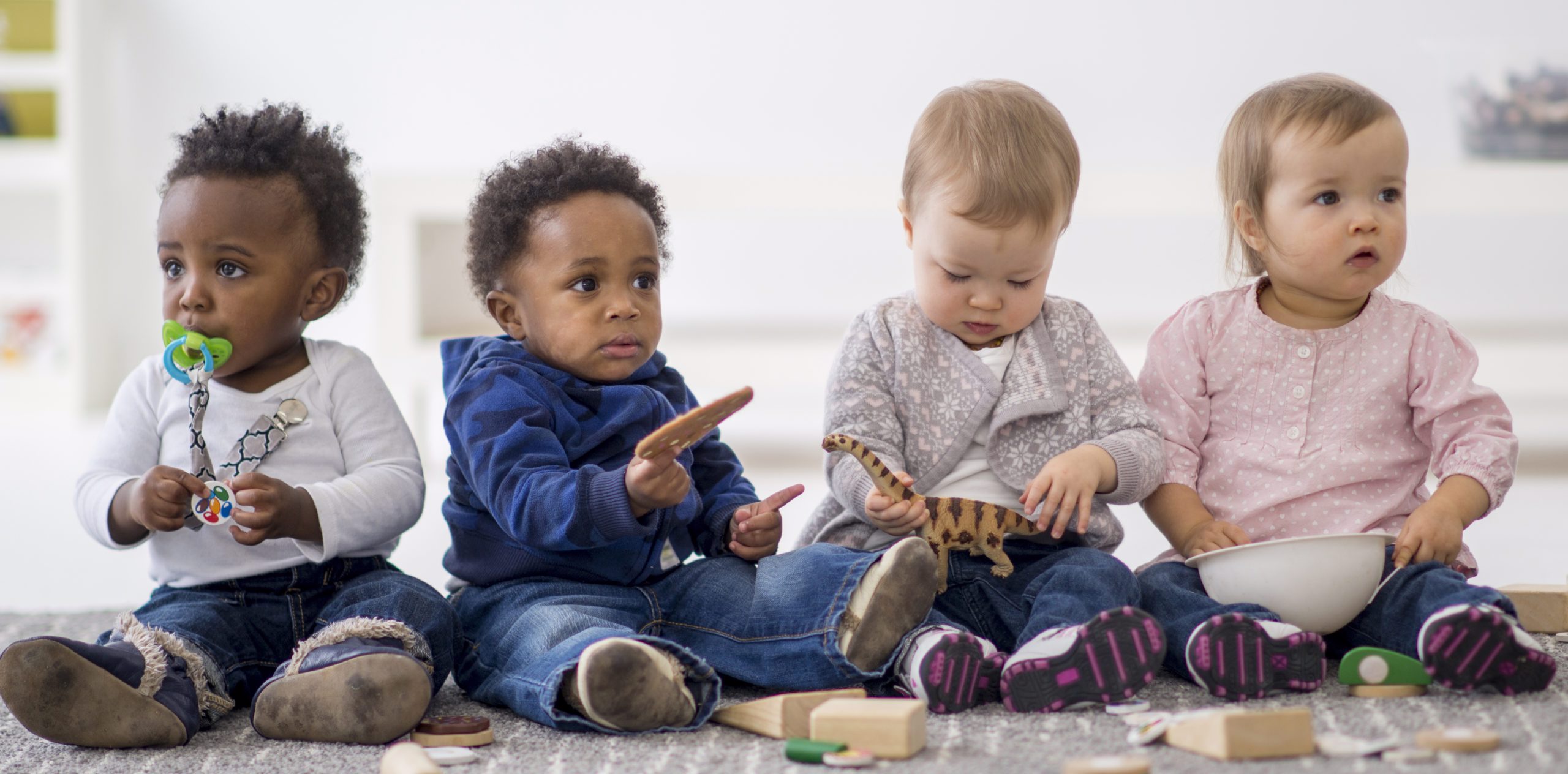 group of toddlers playing together with toys