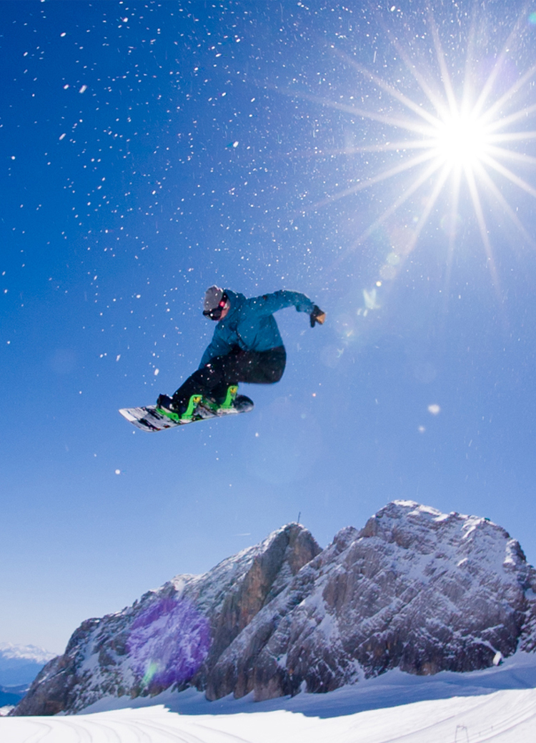 snowboarder making jump on sunny day.