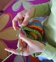 person crocheting with green yarn