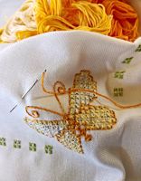 close up of yellow and orange butterfly cross stitch