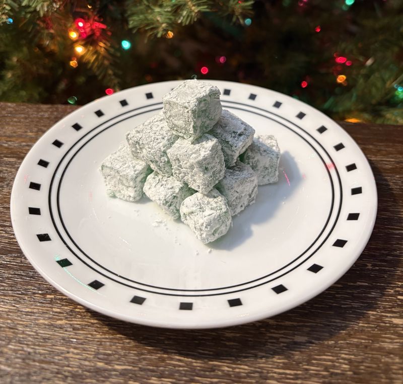 A color photograph of green turkish delight stacked into a pyramid