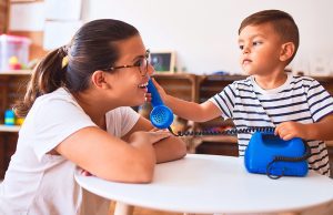 mom and toddler boy playing with toy phone