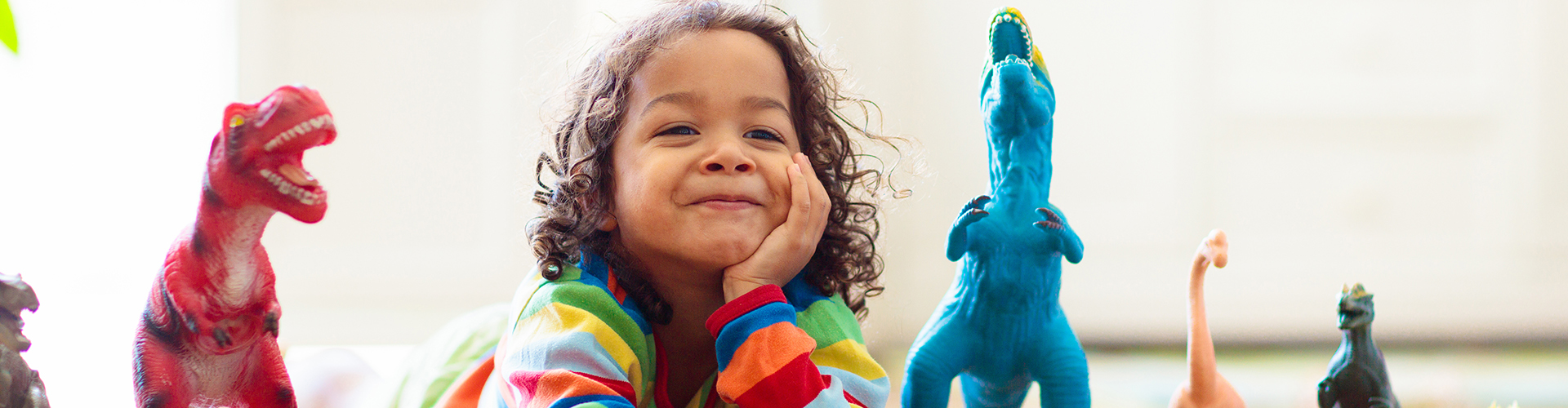 kid with toy dinosaurs