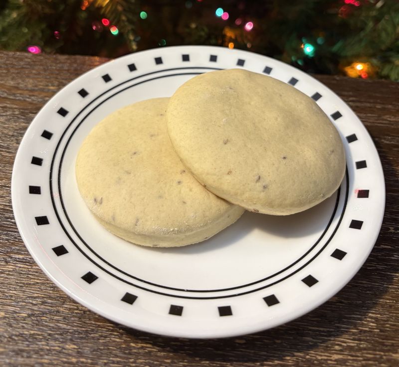 A color photograph of two pale cookies on a white plate