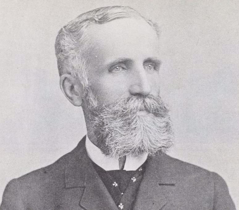 A black and white portrait photograph of Edward Wilder; his hair is slicked back and he has a bushy beard; he wears a dark suit