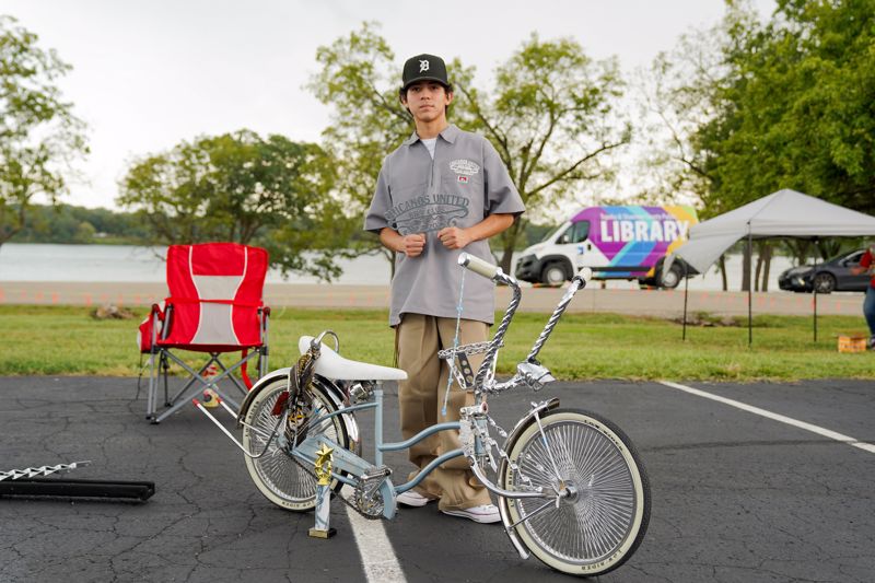man standing next to lowrider bicycle
