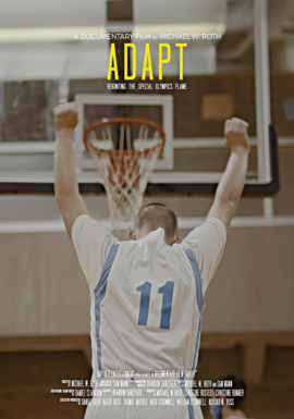 Young boy with arms up facing basketball hoop