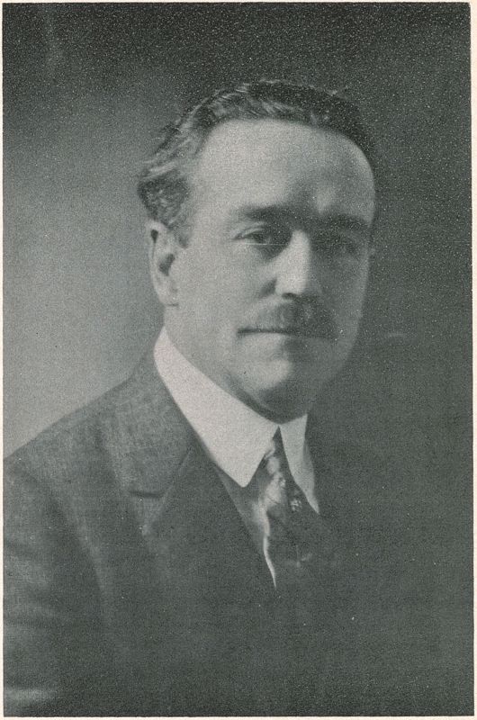 A black and white image of a Charles Fox Parham. He has a bushy mustache and wears a suit and tie.