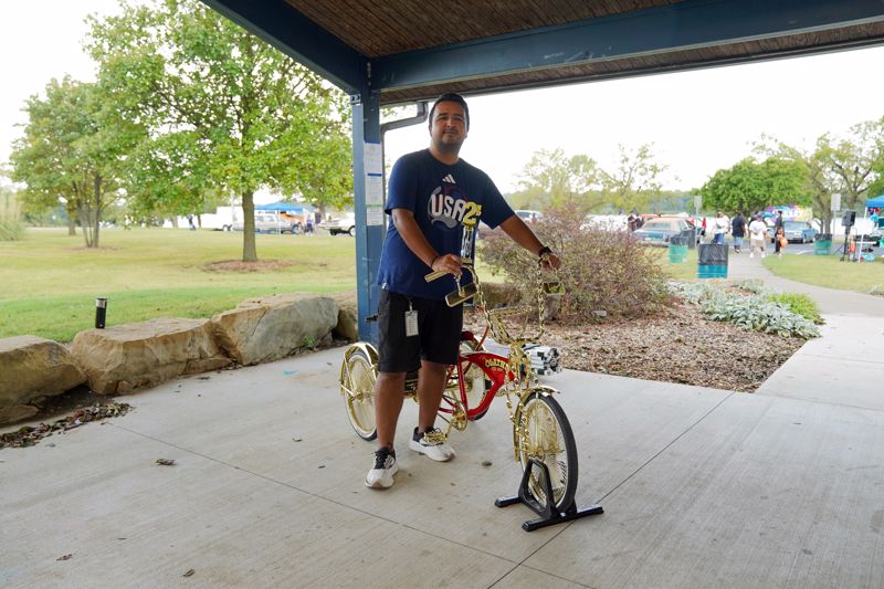 man standing beside lowrider bicycle