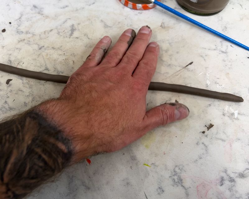 Rolling out a coil with your hand on a flat surface.