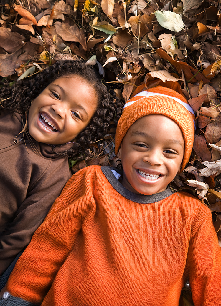 girl and boy smiling in leaves