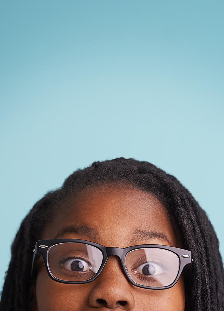girl with glasses peeking over the edge