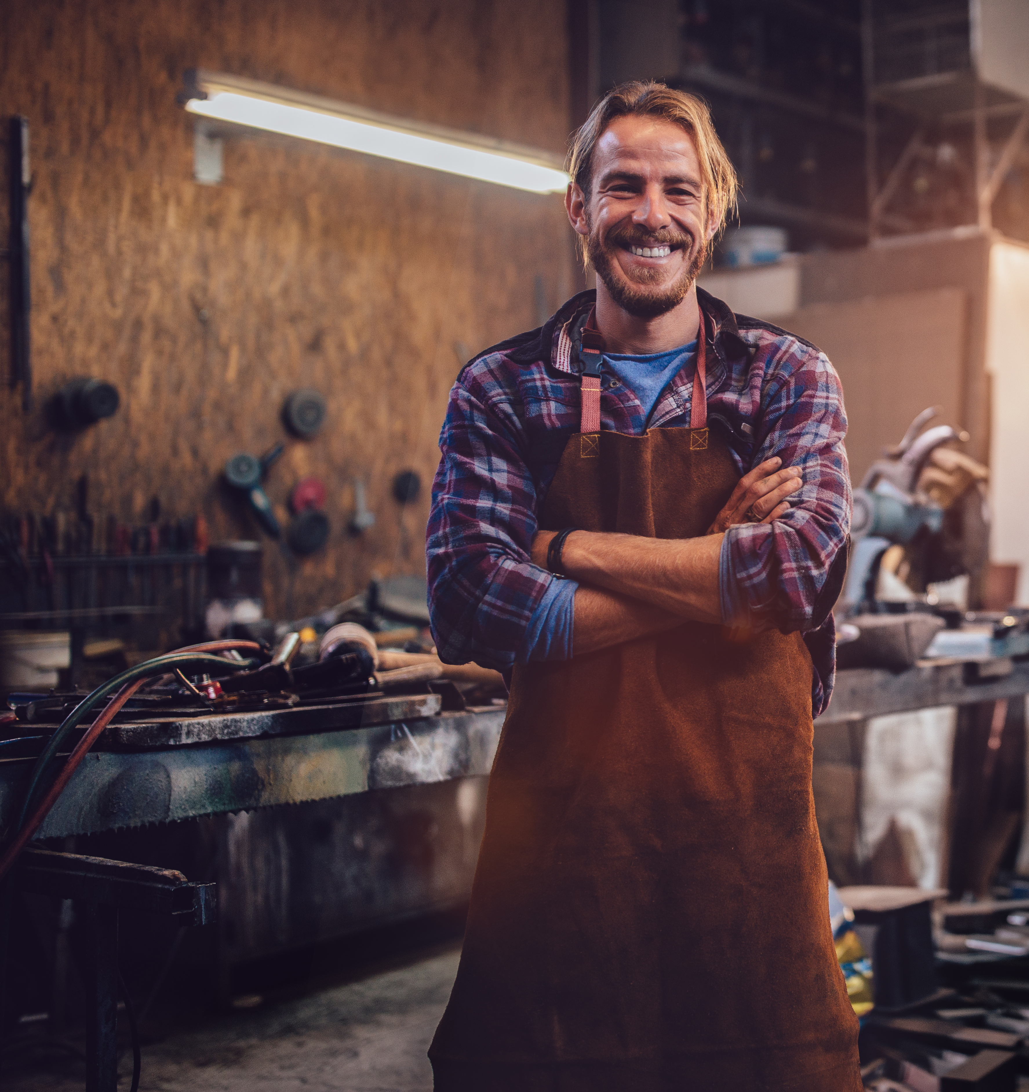 smiling mechanic standing in garage workshop with professional equipment