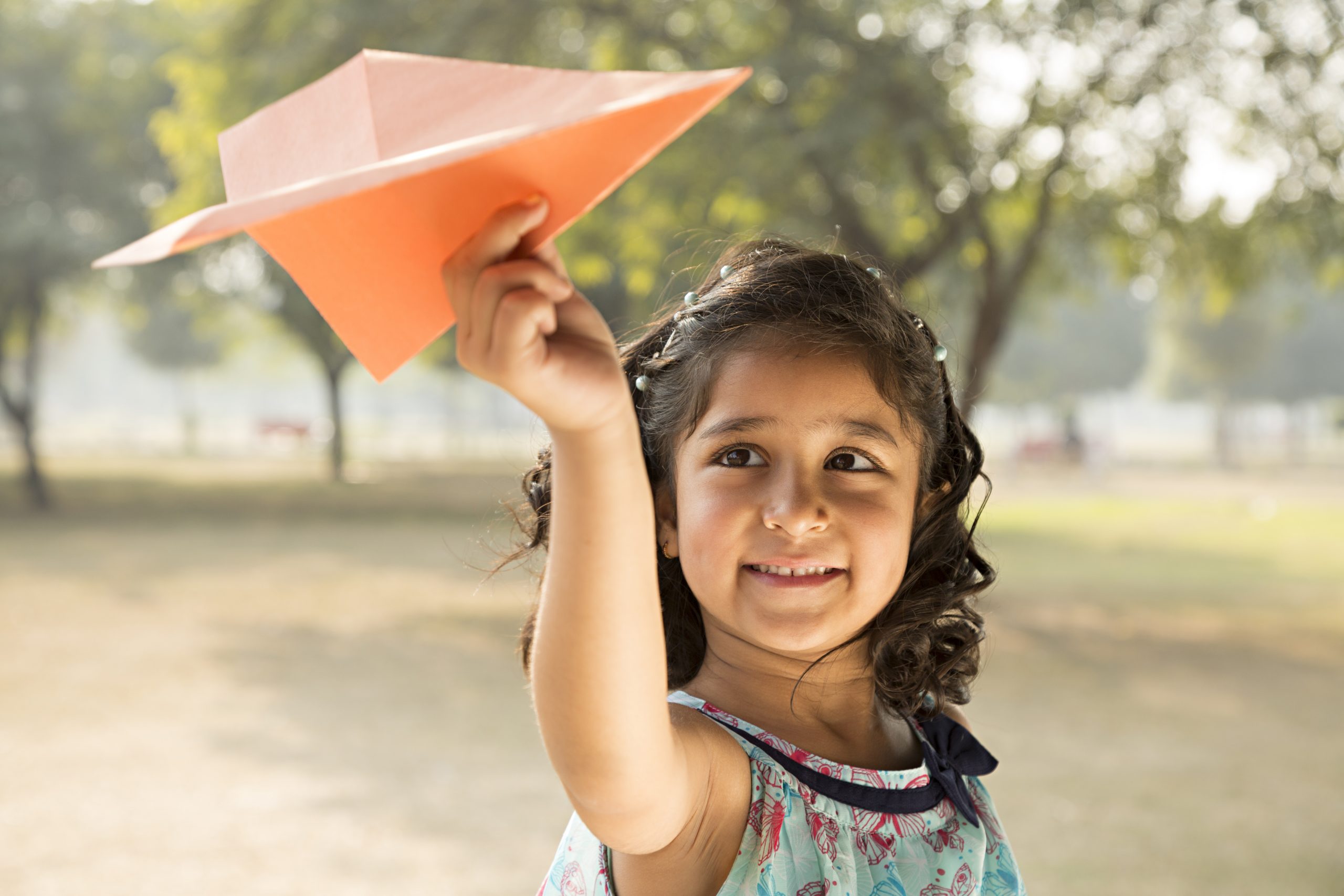 Girl playing with paper airplane