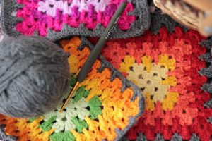 crochet hook and colorful granny squares