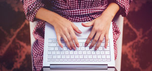 Close-up of woman freelancer's hands typing on laptop keyboard