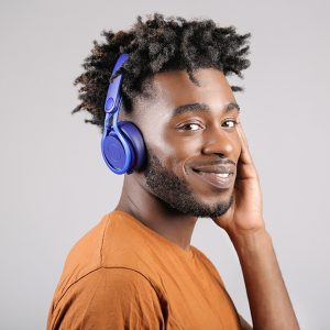 Man wearing an orange t-shirt and blue headphones