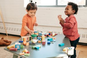 Two toddlers playing with blocks