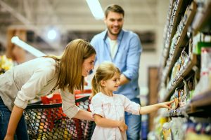 Family with one child shopping together in grocery store.