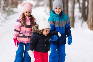 three kids walking in the snow