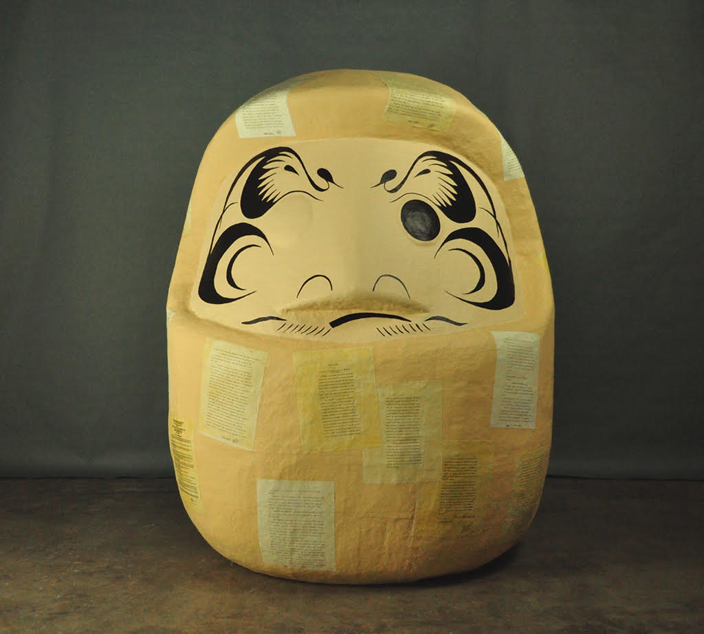 large rounded yellow sculpture with stylized facial features