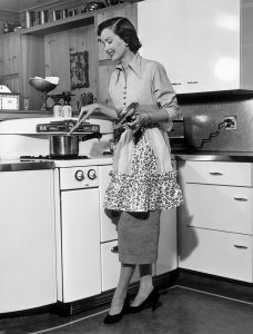 Woman stirring pot at stove circa 1950