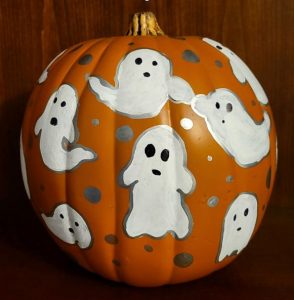 ghosts painted on a foam pumpkin