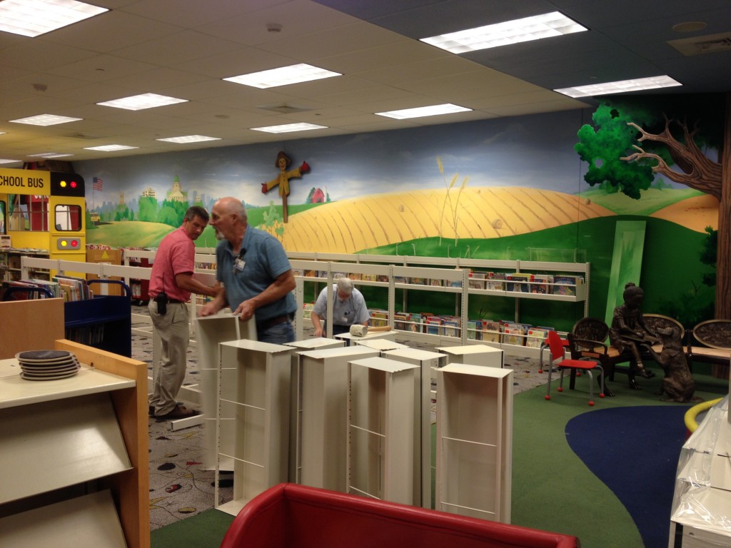 Library staff members assemble bin shelving