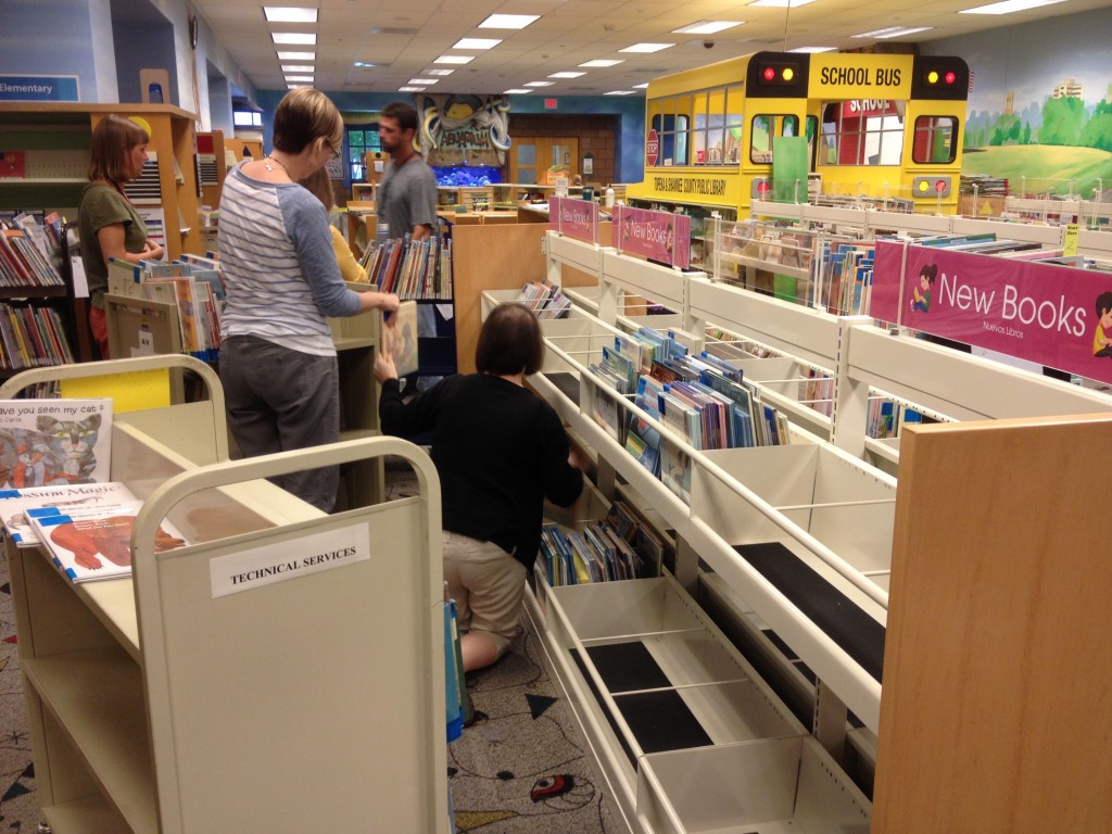 Staff members fill bin shelves