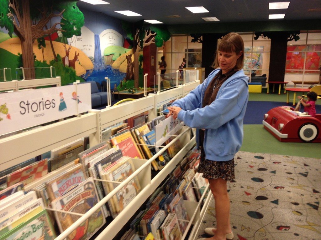 LeAnn installs a new sign above the shelf.