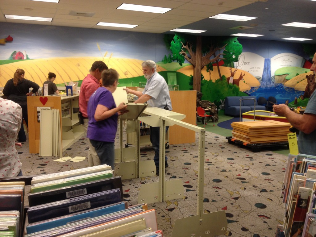 Library staff members dismantle shelves